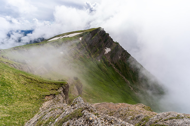 An evocative image capturing a mist-shrouded mountain peak on a cloudy day.